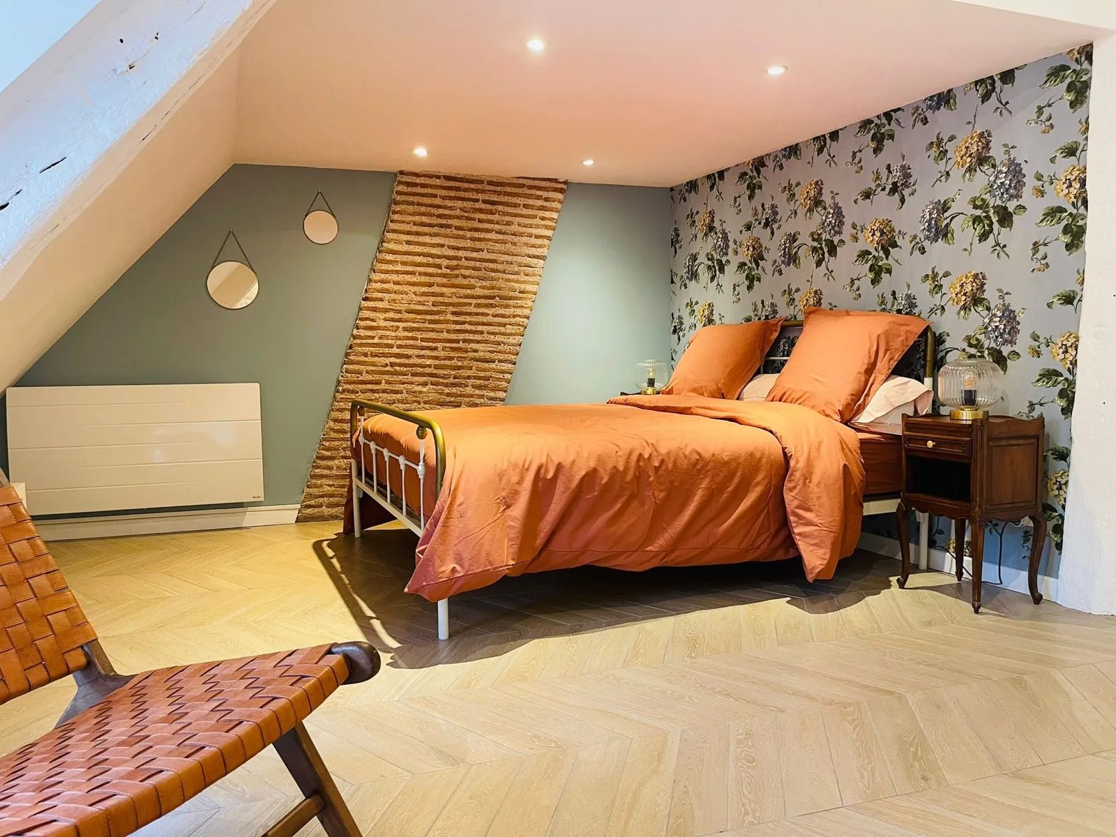 Chambre mansardée sous charpente apparente avec parquet chevron